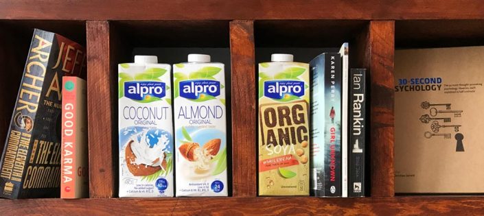 alpro coconut and almond milk on book shelf